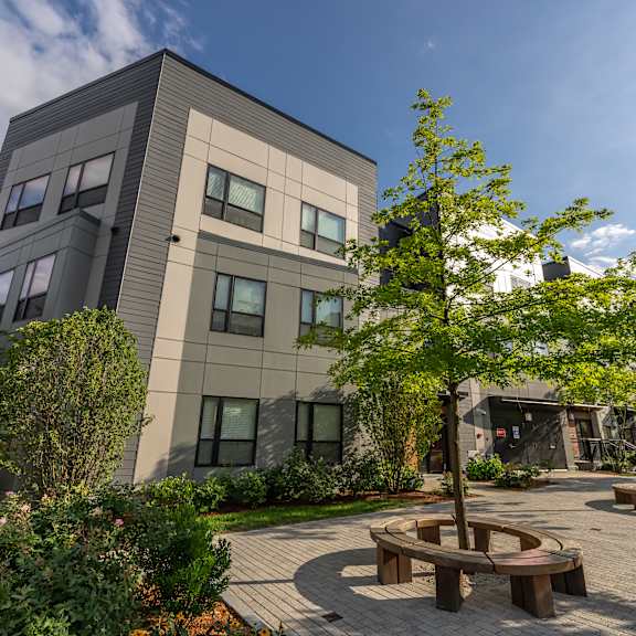 a courtyard with benches and trees in front of a building