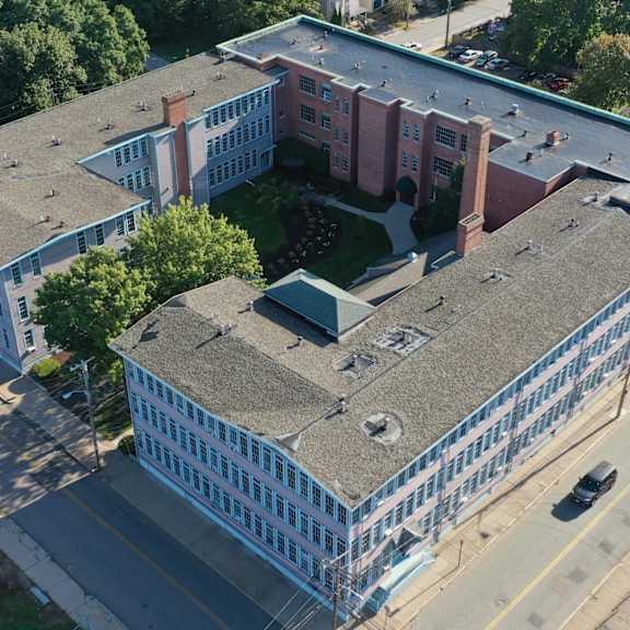 an aerial view of a building with a gray roof