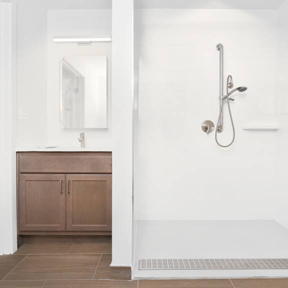 a white bathroom with a shower and a sink