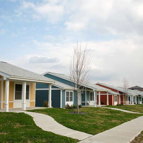 a row of houses in a neighborhood with grass and a sidewalk