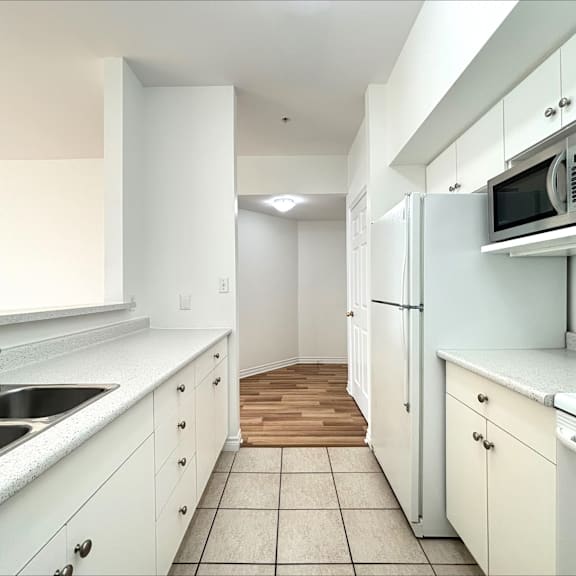 a kitchen with white cabinets and appliances.