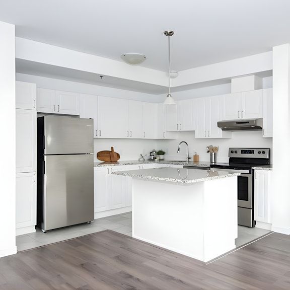 a modern kitchen with a stainless steel refrigerator and a white island.