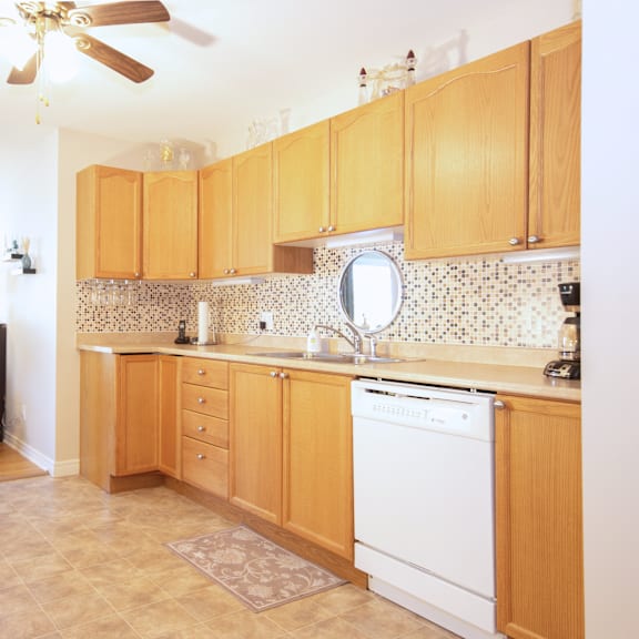 a kitchen with wooden cabinets and a white dishwasher.