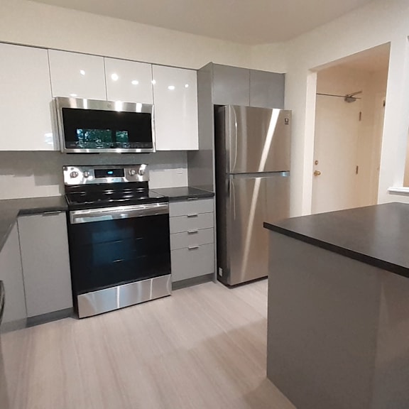 a modern kitchen with stainless steel appliances and white cabinets.