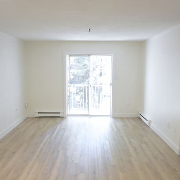 a room with a sliding glass door leading to a balcony.