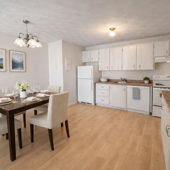 a kitchen with a table set for two and a refrigerator.
