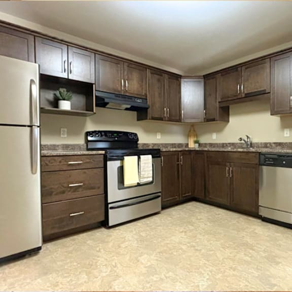 a kitchen with a refrigerator, oven, and sink.