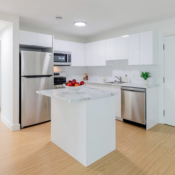 a modern kitchen with a white island in the middle.