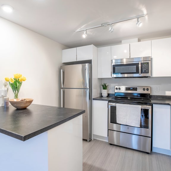 a modern kitchen with a stainless steel refrigerator, oven, and microwave.