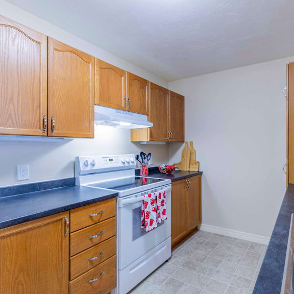 a kitchen with wooden cabinets and a white stove top oven.