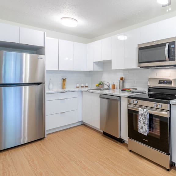 a modern kitchen with a stainless steel refrigerator, oven, and microwave.