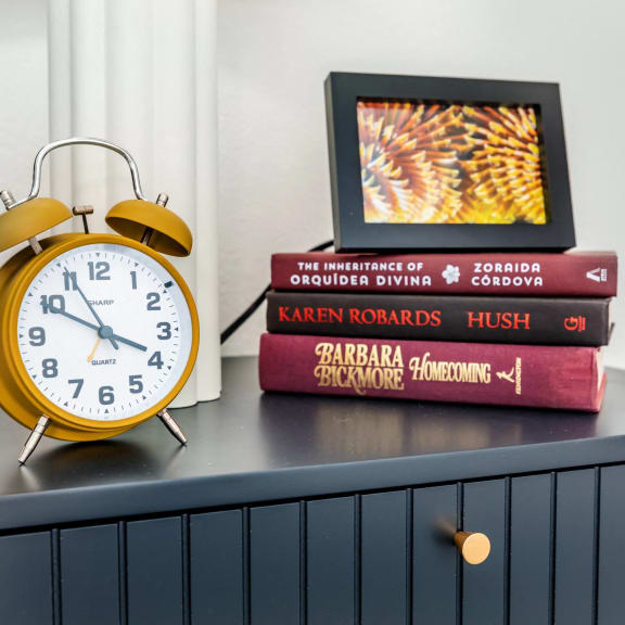 an alarm clock sitting on top of a stack of books