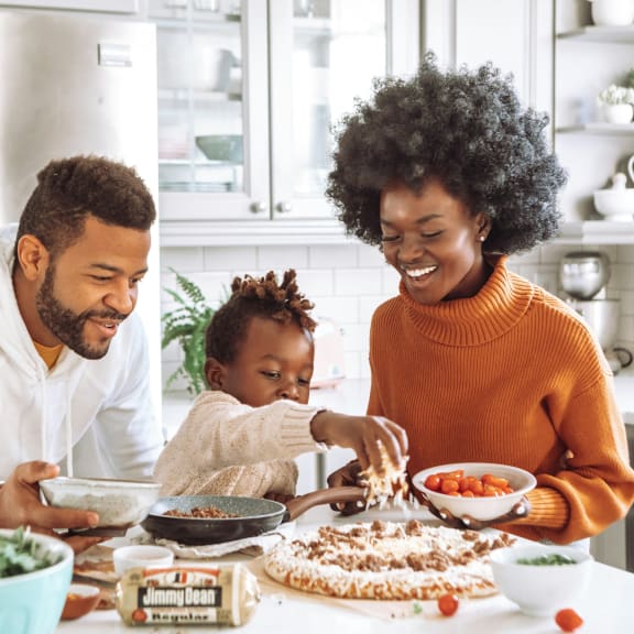 a family sitting at the kitchen table making food together