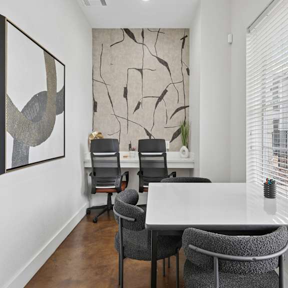 A modern office with a large table and chairs.