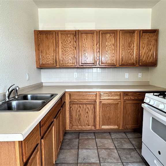 a kitchen with wooden cabinets and white appliances