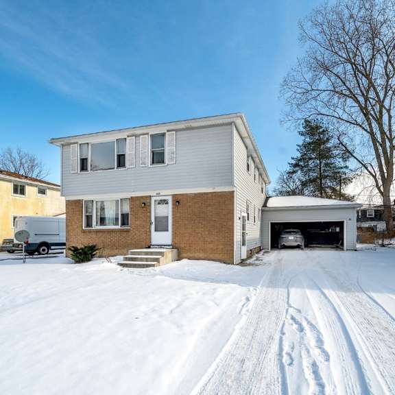 a house with a driveway covered in snow.