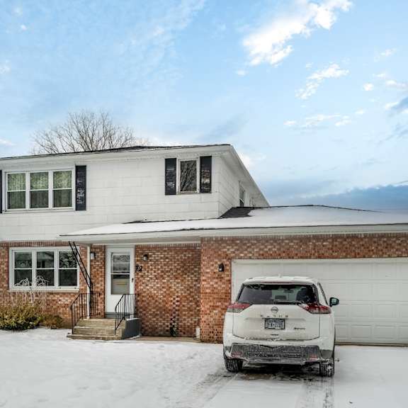 a white car is parked in front of a house.