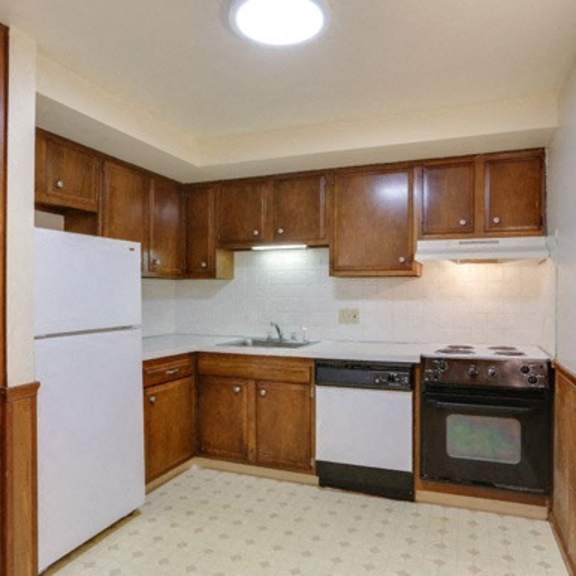 a kitchen with wooden cabinets and a white refrigerator.
