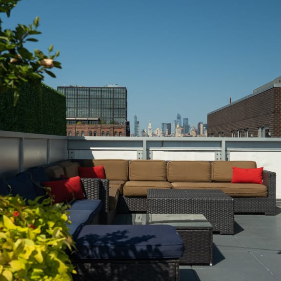a living area on the roof of a building with a couch and tables at 34 Berry, Brooklyn, New York
