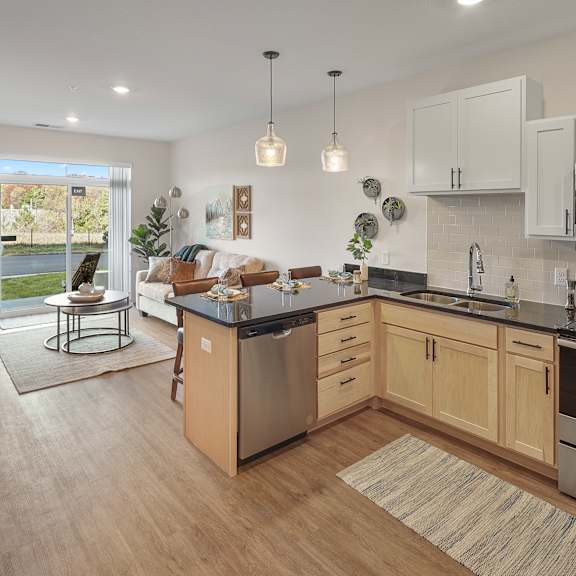 an open kitchen and living room with a couch and a table
