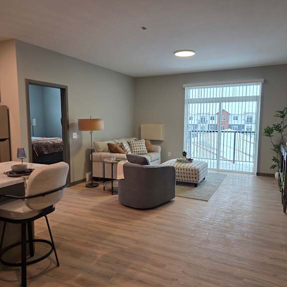 a well-lit living room with a dining table and chairs.