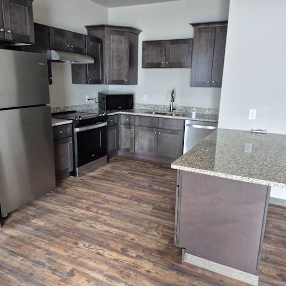 a kitchen with a refrigerator, oven, and microwave.