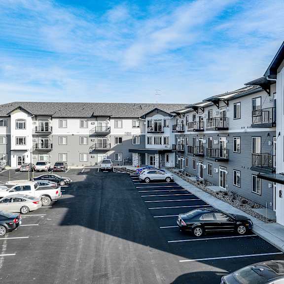 an aerial view of a parking lot in front of apartment buildings