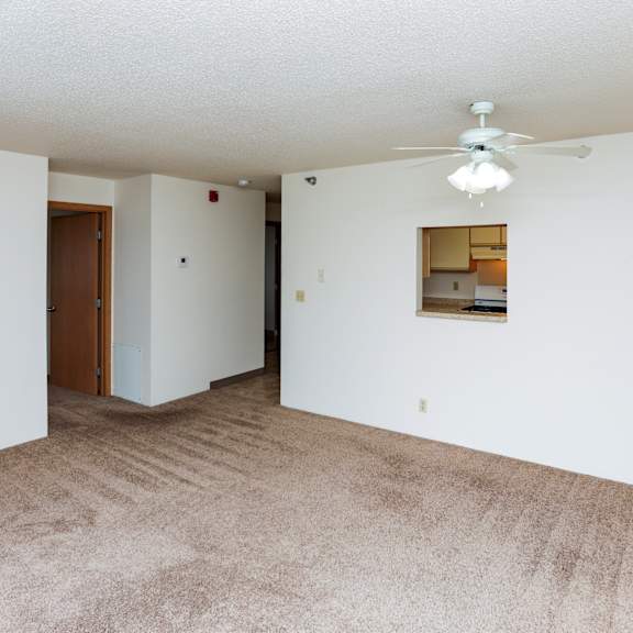 a room with a carpeted floor and a ceiling fan.