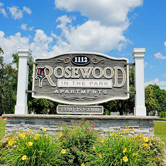 a sign for rosewood apartments is displayed in front of a building.