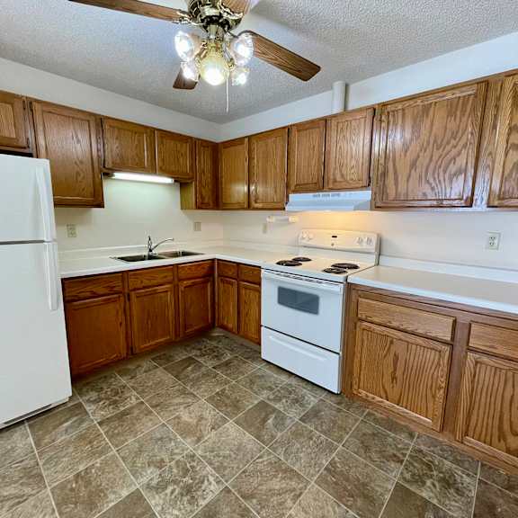 a kitchen with wooden cabinets and a white refrigerator.