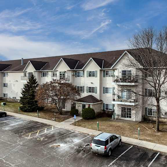 a parking lot in front of a large apartment building.