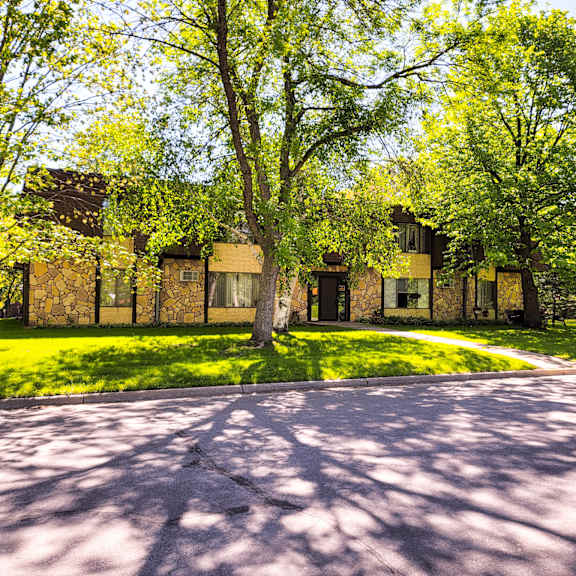 a house with a driveway and trees in front of it.