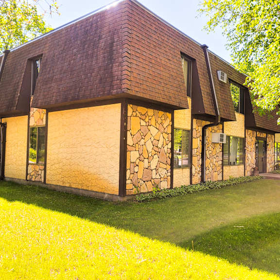 a house with a brown roof and stone walls.