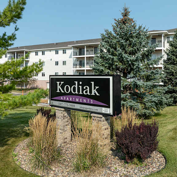 a sign for kodiak apartments is in front of a building.