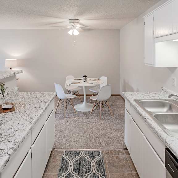 a kitchen with a marble countertop and white cabinets.