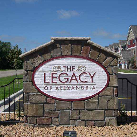 the legacy of alexandria sign in front of a residential area.