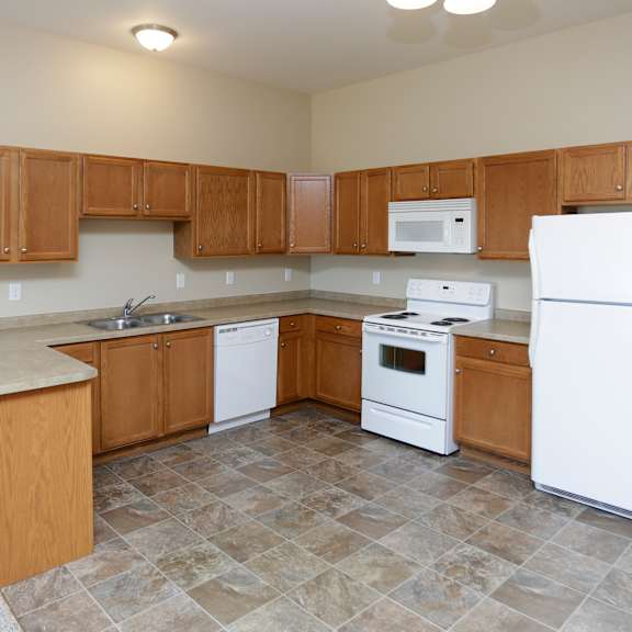 a kitchen with white appliances and wooden cabinets.