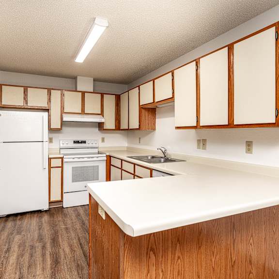 a kitchen with wooden cabinets and a white counter.