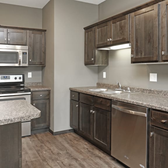 a kitchen with wooden cabinets and granite counter tops and stainless steel appliances