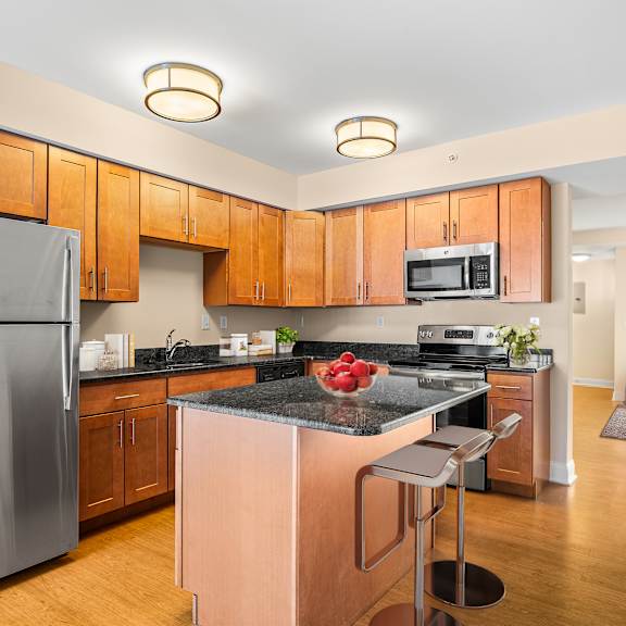 a kitchen with wooden cabinets and a black counter top.