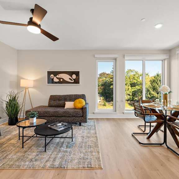 open-concept living space with dining area, wood-inspired floors, granite countertops, and stainless steel appliances at hamilton at eagleview in exton, pa