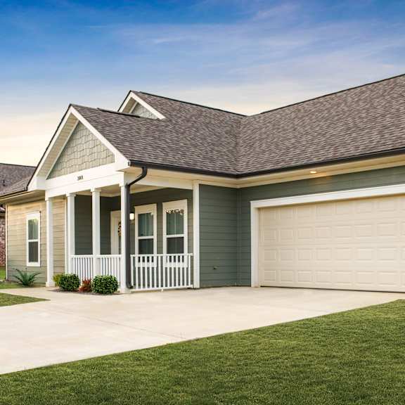 a house with a grey roof and a white garage door.