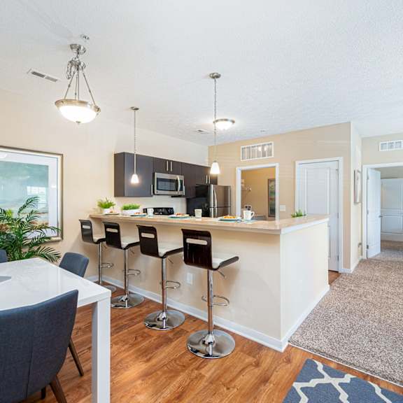 an open kitchen and dining area with a bar and a living room