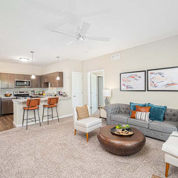 a living room with a couch and a chair and a kitchen