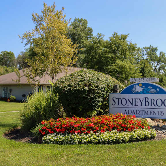 the sign for stoneybrook in front of a garden with colorful flowers