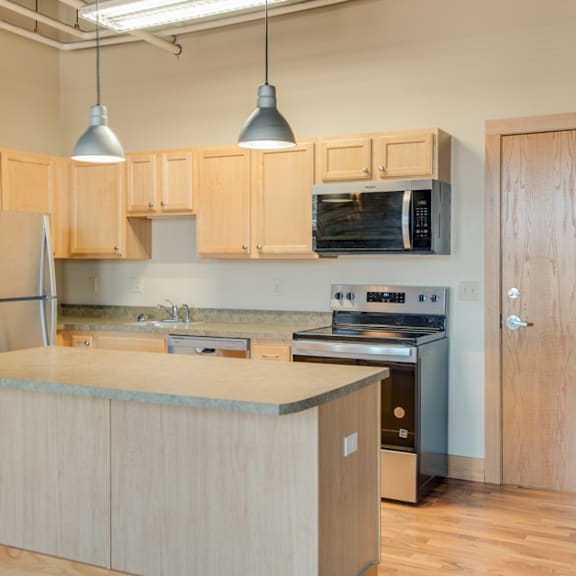a kitchen with wooden cabinets and a stainless steel refrigerator.