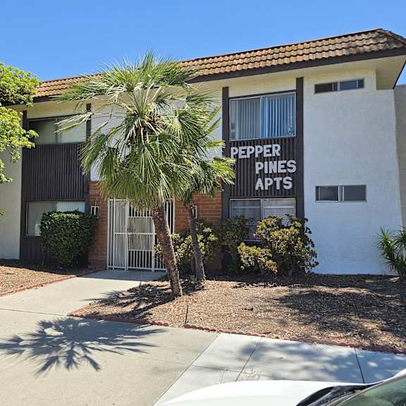 a pepper pines apts sign is on the front of a building.
