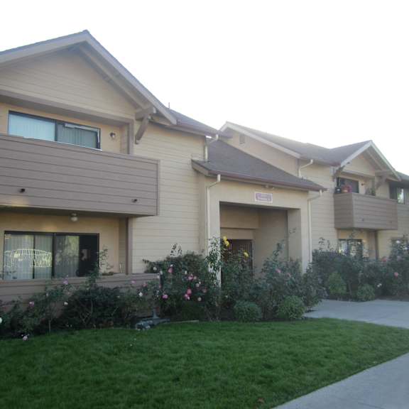 a residential building with a well-maintained lawn in front.