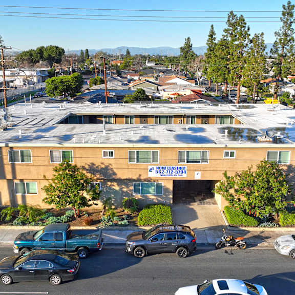 a parking lot with cars and a building in the background.