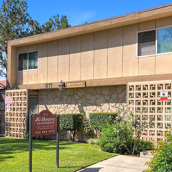 the image shows a building with a sign that reads "jg monterey apartments" and a phone number.